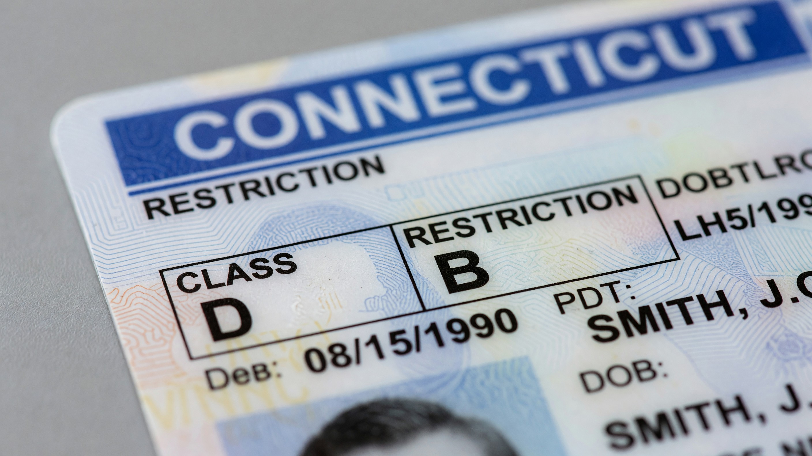Close-up of a Connecticut driver's license showing the class and restriction fields.